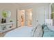 Bright bedroom with light wood floors and en-suite doors, featuring a decorative console table at 3780 Tamiami Trl, Cumming, GA 30041