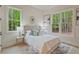 Inviting bedroom with white walls, plush bedding, and bright windows overlooking a wooded view at 3780 Tamiami Trl, Cumming, GA 30041