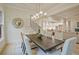 Dining room with views into the kitchen, has stylish light fixture and seats eight at 3780 Tamiami Trl, Cumming, GA 30041