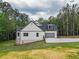 View of a modern two-story home with siding, an attached garage and a spacious green lawn at 3780 Tamiami Trl, Cumming, GA 30041