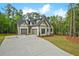 Stylish home with a large concrete driveway and two-car garage, set against a backdrop of mature trees at 3780 Tamiami Trl, Cumming, GA 30041