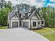 View of a home featuring white siding, grey trim, and a three-car garage at 3780 Tamiami Trl, Cumming, GA 30041