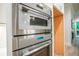 Modern kitchen featuring stainless steel microwave and oven appliances, with light wood flooring at 3780 Tamiami Trl, Cumming, GA 30041