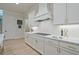 Modern kitchen featuring white cabinets, stainless steel appliances, and light hardwood floors at 3780 Tamiami Trl, Cumming, GA 30041
