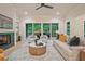 Bright living room with fireplace, natural light, a ceiling fan, and doors leading to an outdoor deck at 3780 Tamiami Trl, Cumming, GA 30041