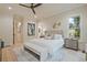 Bright bedroom featuring hardwood floors, modern ceiling fan, with ensuite bathroom access and nature views at 3780 Tamiami Trl, Cumming, GA 30041