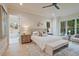 Bright bedroom featuring hardwood floors, modern ceiling fan, and ensuite bathroom with large windows at 3780 Tamiami Trl, Cumming, GA 30041