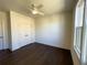 A bright bedroom featuring dark hardwood floors, a modern ceiling fan, and a closet at 160 Chiswick Cir, Alpharetta, GA 30009