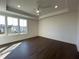 A well-lit bedroom with hardwood floors, a ceiling fan, and three windows is displayed at 160 Chiswick Cir, Alpharetta, GA 30009