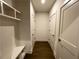 Mudroom with coat rack, bench, storage and two white doors, and hardwood floors at 160 Chiswick Cir, Alpharetta, GA 30009
