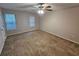 Spacious bedroom with neutral walls, plush carpet, and ceiling fan, providing a serene and comfortable space at 6500 Wellington Chase Ct, Lithonia, GA 30058