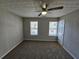 Sunlit bedroom with neutral walls, plush carpet, ceiling fan, and windows offer natural light and comfort at 6500 Wellington Chase Ct, Lithonia, GA 30058
