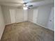 Spacious bedroom with multiple closets, neutral walls, plush carpet, and ceiling fan, providing a serene space at 6500 Wellington Chase Ct, Lithonia, GA 30058