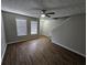 Bright living room with hardwood floors, ceiling fan, and natural light from two large windows at 6500 Wellington Chase Ct, Lithonia, GA 30058