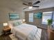 Bedroom with a bed dressed in white linens and art deco on the walls, two windows for natural light at 6500 Wellington Chase Ct, Lithonia, GA 30058