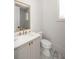 Bright bathroom featuring marble floors, a white vanity, and a gold-framed mirror at 10931 Serenbe Ln, Chattahoochee Hills, GA 30268