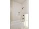 Well-lit bathroom showcasing modern tilework, a bathtub, and bronze shower fixtures at 10931 Serenbe Ln, Chattahoochee Hills, GA 30268