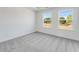 Bright bedroom features plush gray carpeting and two windows for ample natural light at 3269 Durston Ct, Dacula, GA 30019