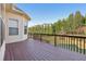 Wooden deck with an outdoor view of trees, green space, neighborhood homes and blue sky at 2420 Bronze Ct, Cumming, GA 30041