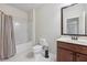 Bright bathroom with shower-tub, toilet, and vanity with a mirror at 2420 Bronze Ct, Cumming, GA 30041