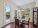 Eat-in breakfast nook with hardwood floors, modern chandelier, table, chairs and backyard view at 2420 Bronze Ct, Cumming, GA 30041