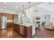 Open kitchen featuring a center island, stainless appliances, wood cabinets and seamless access to living room at 2420 Bronze Ct, Cumming, GA 30041