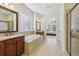 Main bathroom with double vanity, soaking tub, and tiled walk-in shower at 2420 Bronze Ct, Cumming, GA 30041