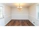Bright dining room features classic wainscoting and a stylish chandelier at 407 Robins Nest Ct, Woodstock, GA 30189