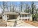 Home's exterior shows the carport, front porch, and stone foundation at 407 Robins Nest Ct, Woodstock, GA 30189