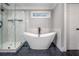 Modern bathroom with a stand alone tub, glass enclosed shower, and hexagon tile flooring at 1375 Miller Reed Se Ave, Atlanta, GA 30315
