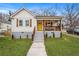 Charming home featuring a bright yellow door, shuttered windows, and a cozy, covered front porch at 1375 Miller Reed Se Ave, Atlanta, GA 30315
