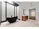 A sleek bathroom boasts a freestanding tub under a skylight, a patterned floor, and a wood vanity with marble countertop at 3488 Tuxedo Nw Rd, Atlanta, GA 30305