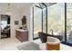 This bathroom features a freestanding tub under a skylight, a decorative chair, and a wood vanity with marble countertop at 3488 Tuxedo Nw Rd, Atlanta, GA 30305