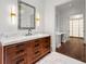 Bright bathroom featuring a wood vanity with marble countertop, decorative lighting, and access to walk-in closet at 3488 Tuxedo Nw Rd, Atlanta, GA 30305