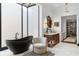 A bright bathroom features a modern tub beneath a skylight, a stylish chair, and a wood vanity with marble top at 3488 Tuxedo Nw Rd, Atlanta, GA 30305