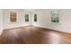 Sunlit bedroom features hardwood floors and three windows with backyard views at 3488 Tuxedo Nw Rd, Atlanta, GA 30305