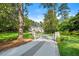 Serene view of the property entrance with stone pillars and an elegant driveway leading to a beautiful home surrounded by trees at 3488 Tuxedo Nw Rd, Atlanta, GA 30305