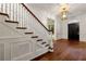 Bright foyer with hardwood floors, stairs with white banister, and black front door at 3488 Tuxedo Nw Rd, Atlanta, GA 30305