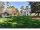 Expansive front yard with lush green lawn, a guest house, and a charming two-story white home with black accents at 3488 Tuxedo Nw Rd, Atlanta, GA 30305