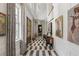 Elegant hallway features herringbone marble floors, wainscoting, natural light, and decorative art at 3488 Tuxedo Nw Rd, Atlanta, GA 30305