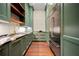An elegant kitchen features green cabinetry, granite counters, and stainless steel refrigerator at 3488 Tuxedo Nw Rd, Atlanta, GA 30305