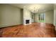 Spacious living room featuring herringbone wood floors, a decorative fireplace, and large windows providing plenty of natural light at 3488 Tuxedo Nw Rd, Atlanta, GA 30305