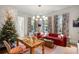 Bright living room featuring a red sofa, stylish curtains, and a unique light fixture at 3488 Tuxedo Nw Rd, Atlanta, GA 30305