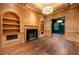 Spacious living room featuring a fireplace, custom wood paneling, and beautiful hardwood floors at 3488 Tuxedo Nw Rd, Atlanta, GA 30305