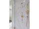 A close up of gold shower hardware against marble walls in this primary bath at 3488 Tuxedo Nw Rd, Atlanta, GA 30305