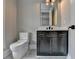 Modern powder room with dark vanity, marble floors, and a frameless mirror at 3609 Centerville Rosebud Rd, Snellville, GA 30039