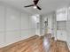 Bright bedroom with hardwood floors, wainscoting, and a ceiling fan; access to hallway at 3609 Centerville Rosebud Rd, Snellville, GA 30039