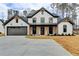 Two-story farmhouse with gray accents, a metal roof, and a large driveway at 3609 Centerville Rosebud Rd, Snellville, GA 30039