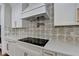 Modern kitchen features white cabinets, patterned backsplash, and a sleek cooktop at 3609 Centerville Rosebud Rd, Snellville, GA 30039