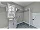 Bright laundry room with white cabinets, a utility sink, and dark grey tile floor at 3609 Centerville Rosebud Rd, Snellville, GA 30039